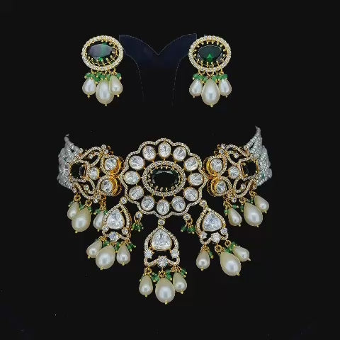 Emerald-green central stones and cascading pearl-and-bead drop accents kundan and pearl jewelry set.