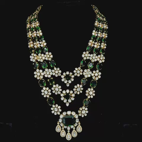 Emerald-tinted gemstone beads and drops, culminating in a grand central emerald pendant.