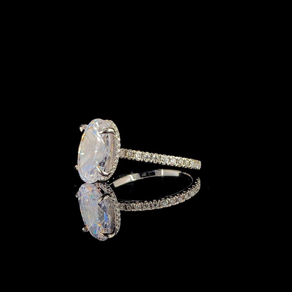 18k white gold engagement ring features a large 3.00 ct oval center diamond with a pave band.
