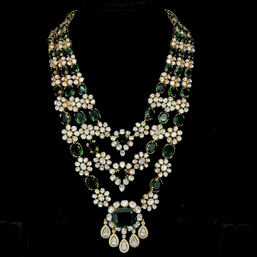 Emerald-tinted gemstone beads and drops, culminating in a grand central emerald pendant.