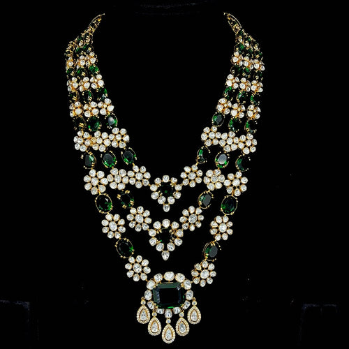 Emerald-tinted gemstone beads and drops, culminating in a grand central emerald pendant.