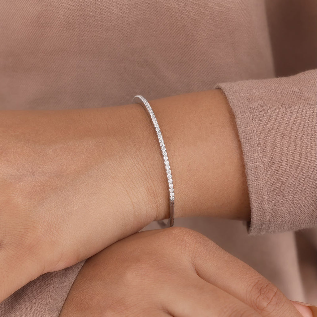 White gold band set with a shimmering row of brilliant-cut round accent stones and a secure box clasp closure.