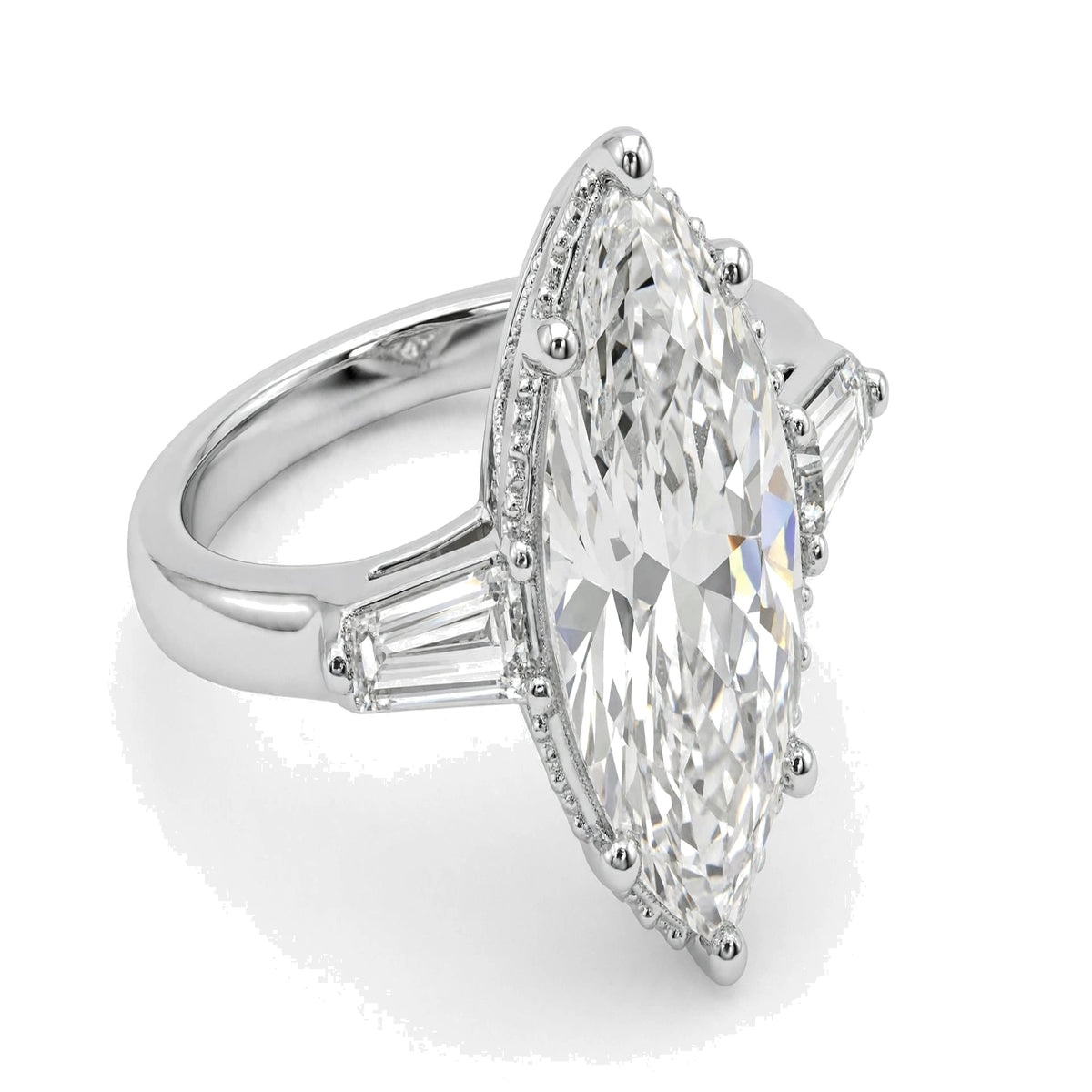 Large center marquise-cut diamond accented by tapered baguette side stones and delicate milgrain detailing.
