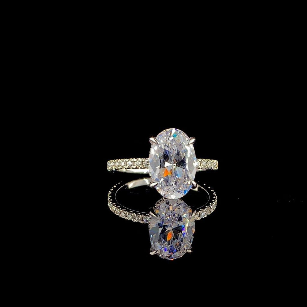 18k white gold engagement ring features a large 3.00 ct oval center diamond with a pave band.