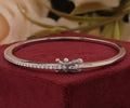 White gold band set with a shimmering row of brilliant-cut round accent stones and a secure box clasp closure.