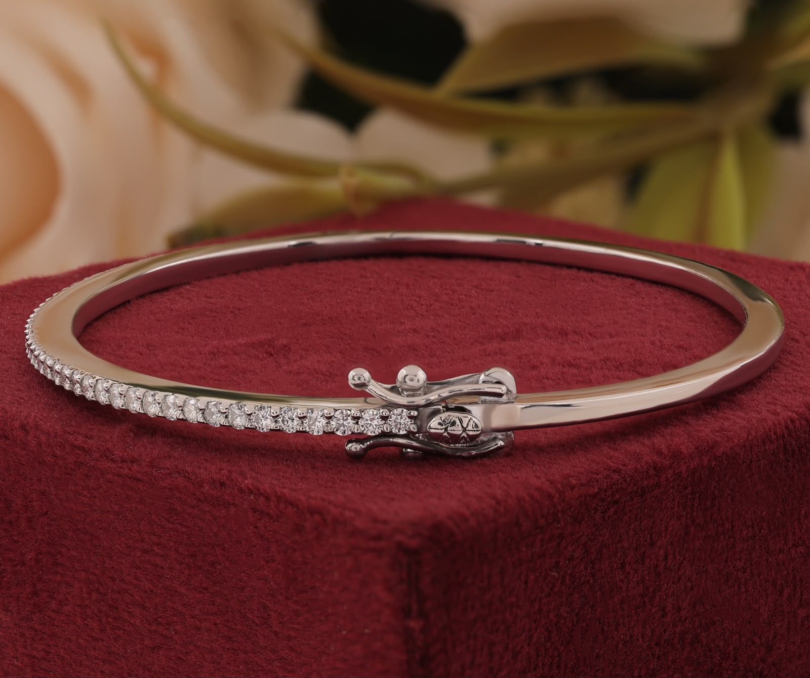 White gold band set with a shimmering row of brilliant-cut round accent stones and a secure box clasp closure.