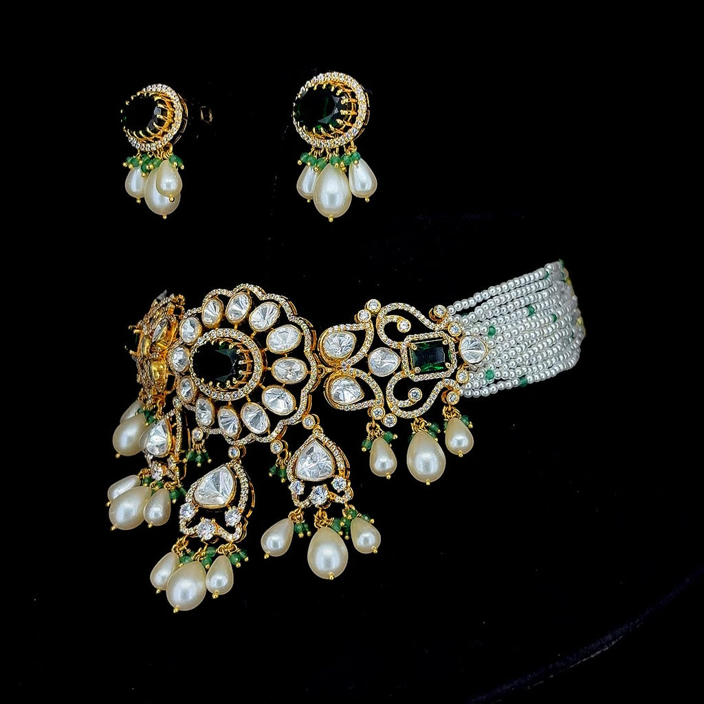 Emerald-green central stones and cascading pearl-and-bead drop accents kundan and pearl jewelry set.