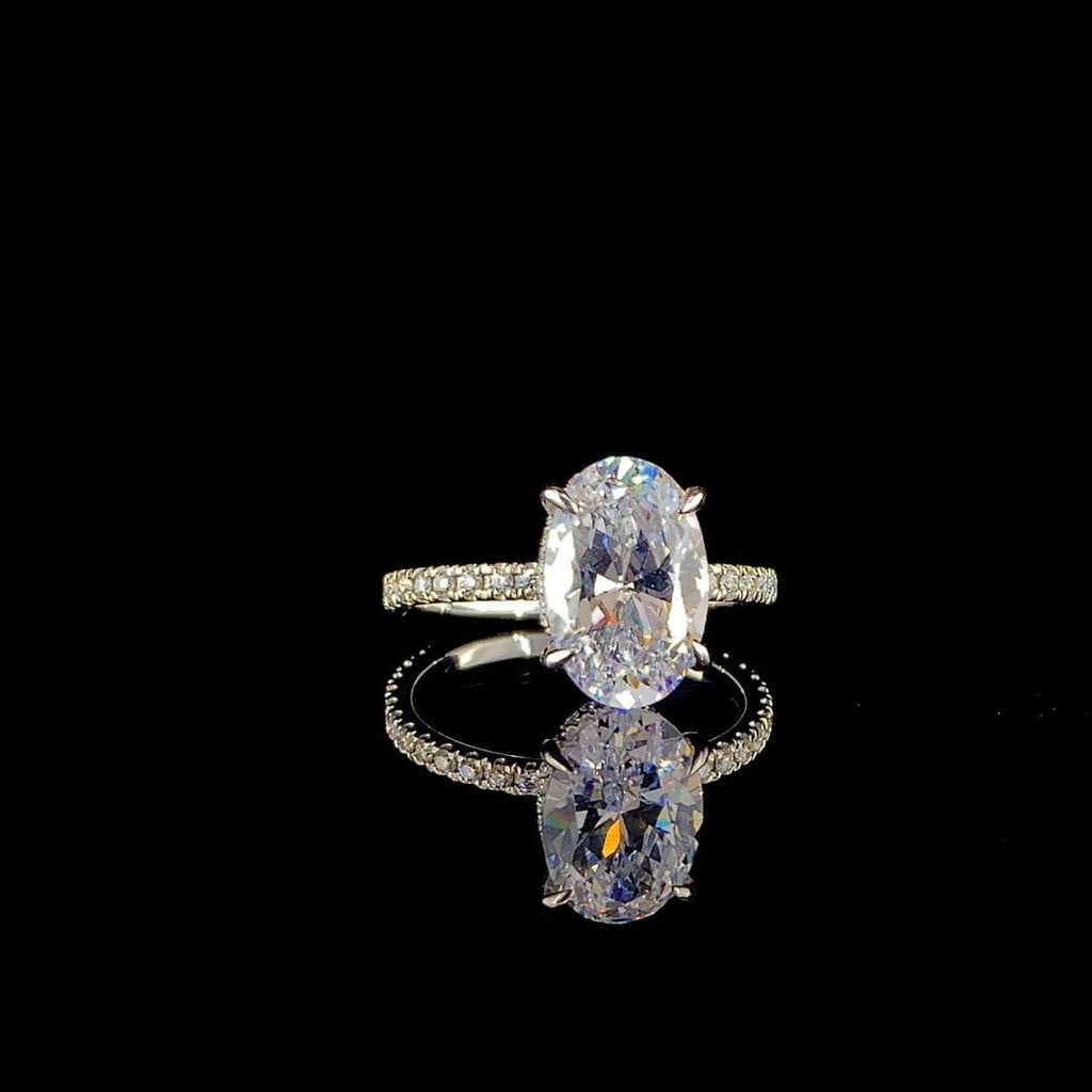 18k white gold engagement ring features a large 3.00 ct oval center diamond with a pave band.