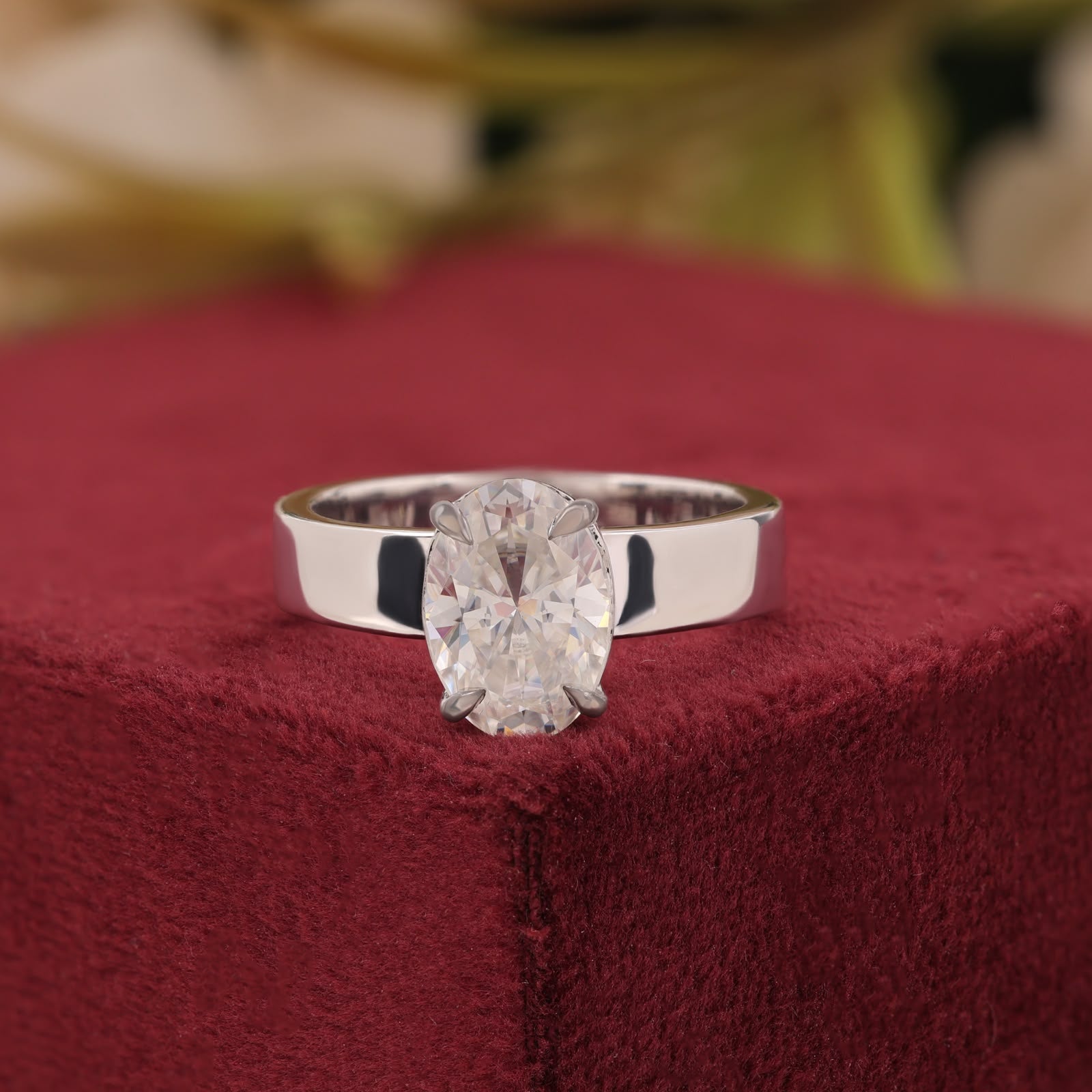 Oval-cut center stone set in a polished white gold wide band engagement ring.