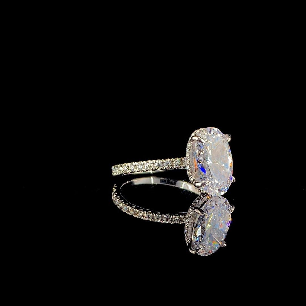 18k white gold engagement ring features a large 3.00 ct oval center diamond with a pave band.
