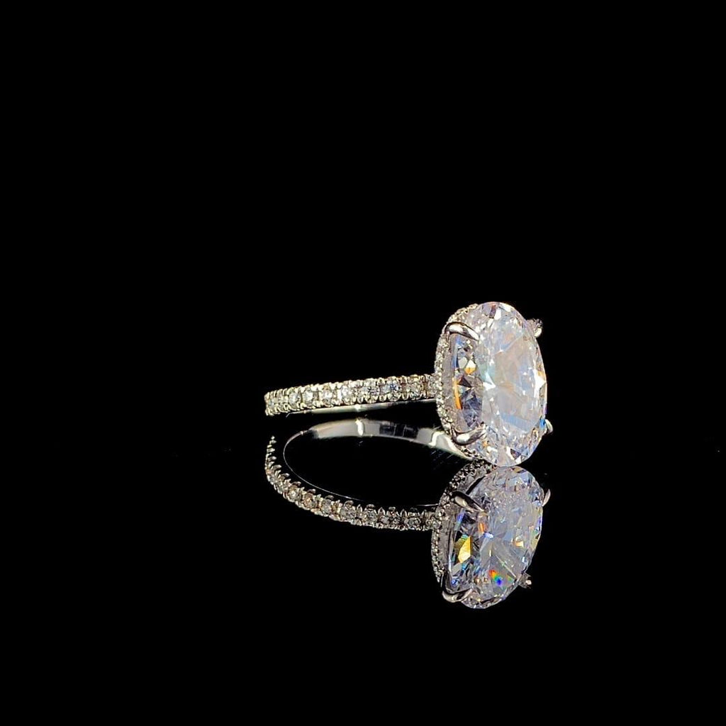 18k white gold engagement ring features a large 3.00 ct oval center diamond with a pave band.