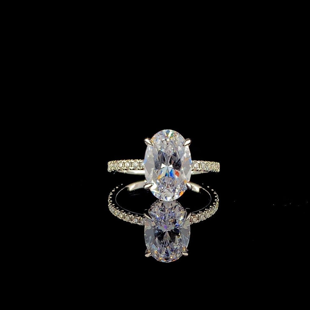18k white gold engagement ring features a large 3.00 ct oval center diamond with a pave band.