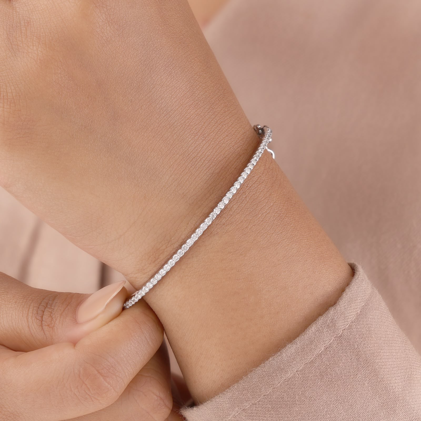 White gold band set with a shimmering row of brilliant-cut round accent stones and a secure box clasp closure.