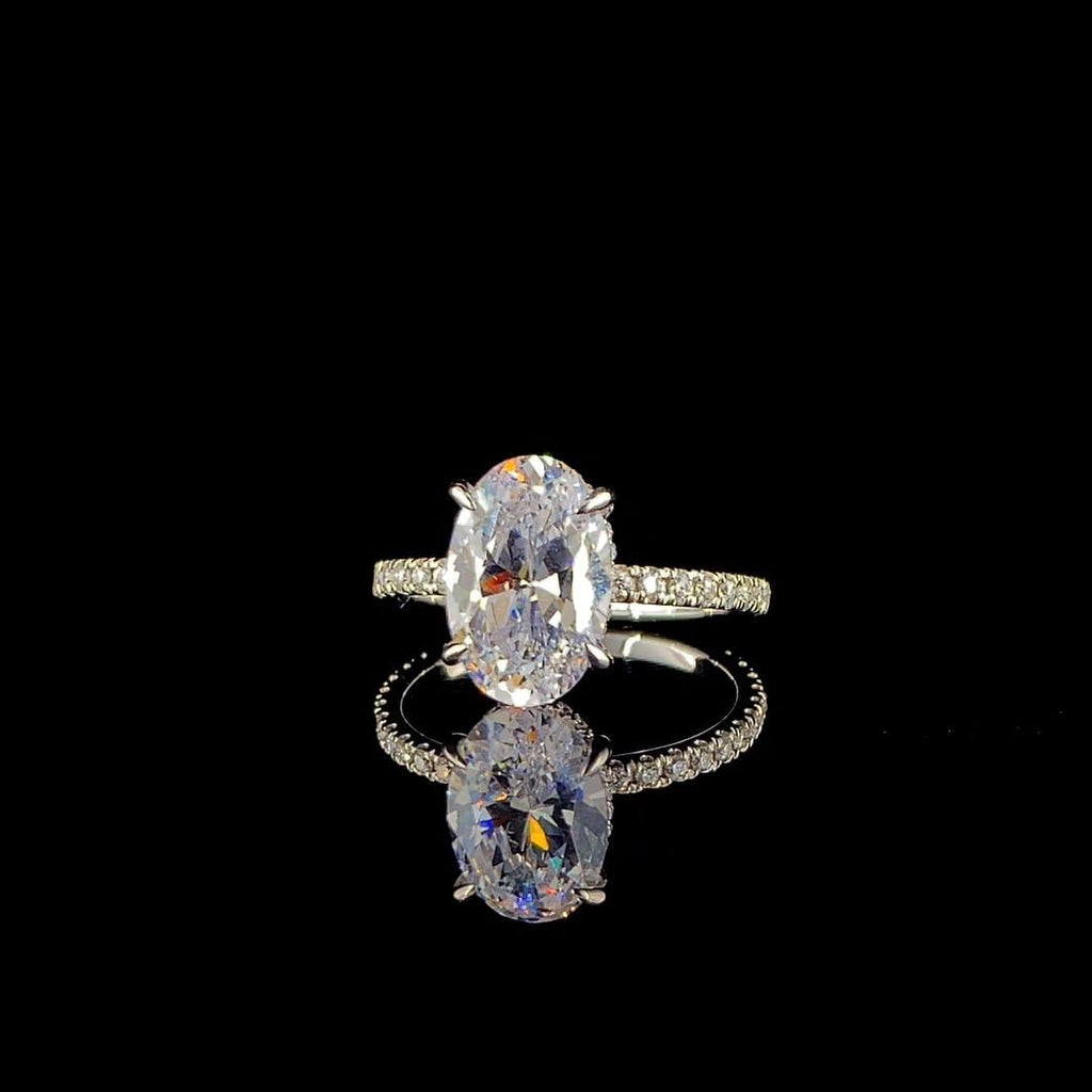18k white gold engagement ring features a large 3.00 ct oval center diamond with a pave band.