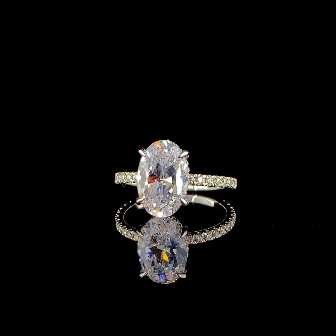 18k white gold engagement ring features a large 3.00 ct oval center diamond with a pave band.